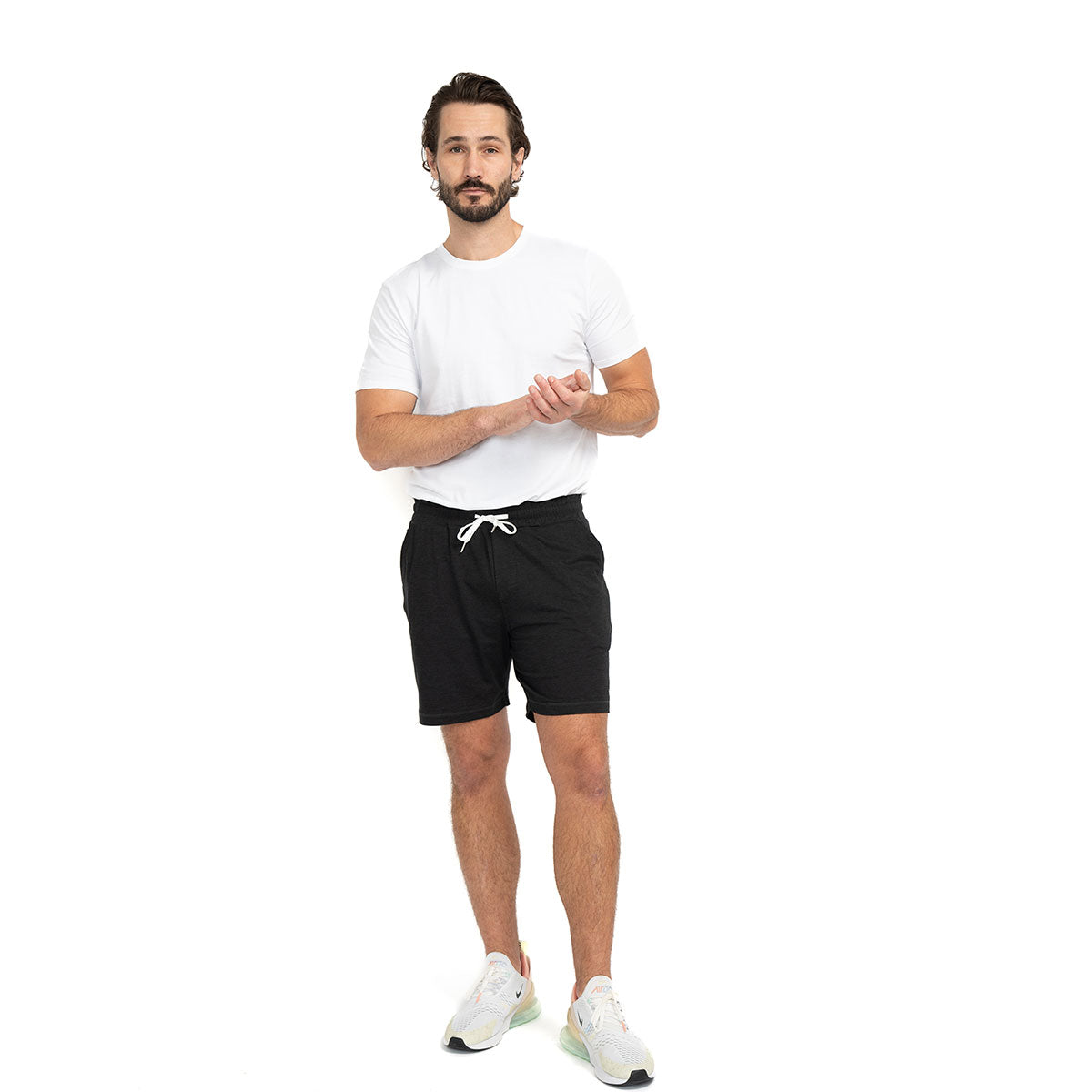 Man wearing black Ejis Conquest Athletic Shorts and a white tshirt