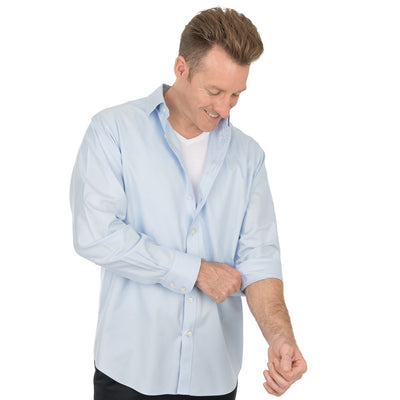 Man rulling up the sleeve of a light blue shirt over a white Ejis cotton sweat proof undershirt on a white background