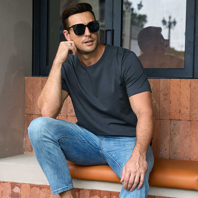 man wearing grey TotalShield t-shirt sitting on a bench outside