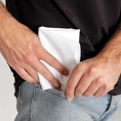man putting white Ejis handkerchief into his pocket