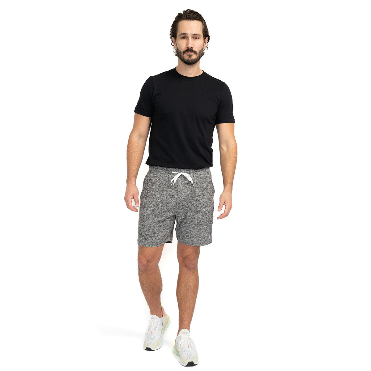 Man wearing light grey Ejis Conquest Athletic Shorts and a black tshirt