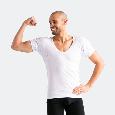 Man flexing his arm wearing a white Ejis deep v micro modal undershirt and black Ejis sweat proof boxer briefs on a light gray background