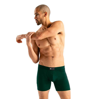 man wearing green Ejis essential boxer briefs while stretching arm