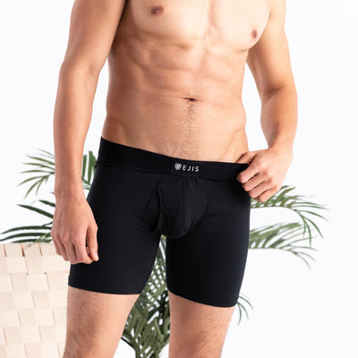 Man wearing black Ejis sweat proof boxer briefs with a visible logo on a neutral background