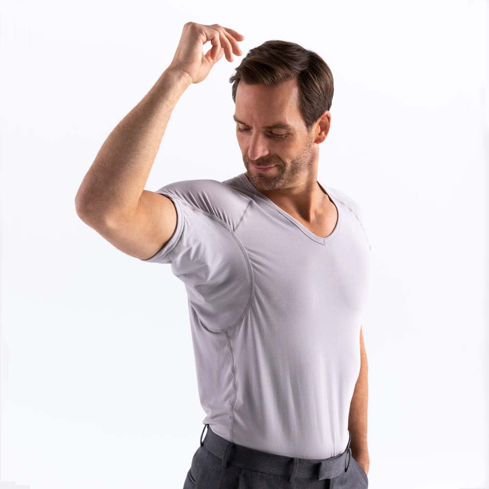 man holding arm up wearing grey Ejis v-neck micro modal sweat proof undershirt and dress pants